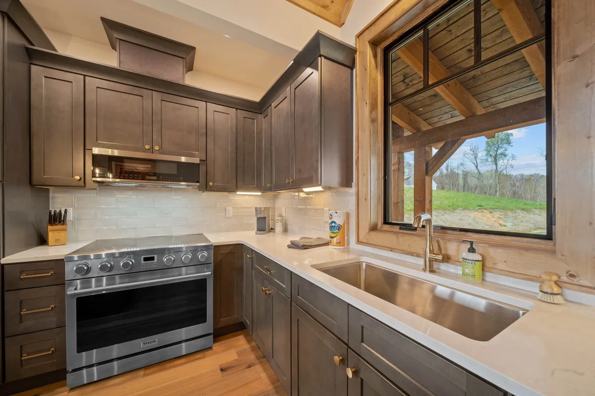 A close-up view of a modern stove with stainless finish, an inviting sink, and a window that lets in natural light. The scene is intimate and practical, highlighting spaces where family meals and creative recipes come to life.